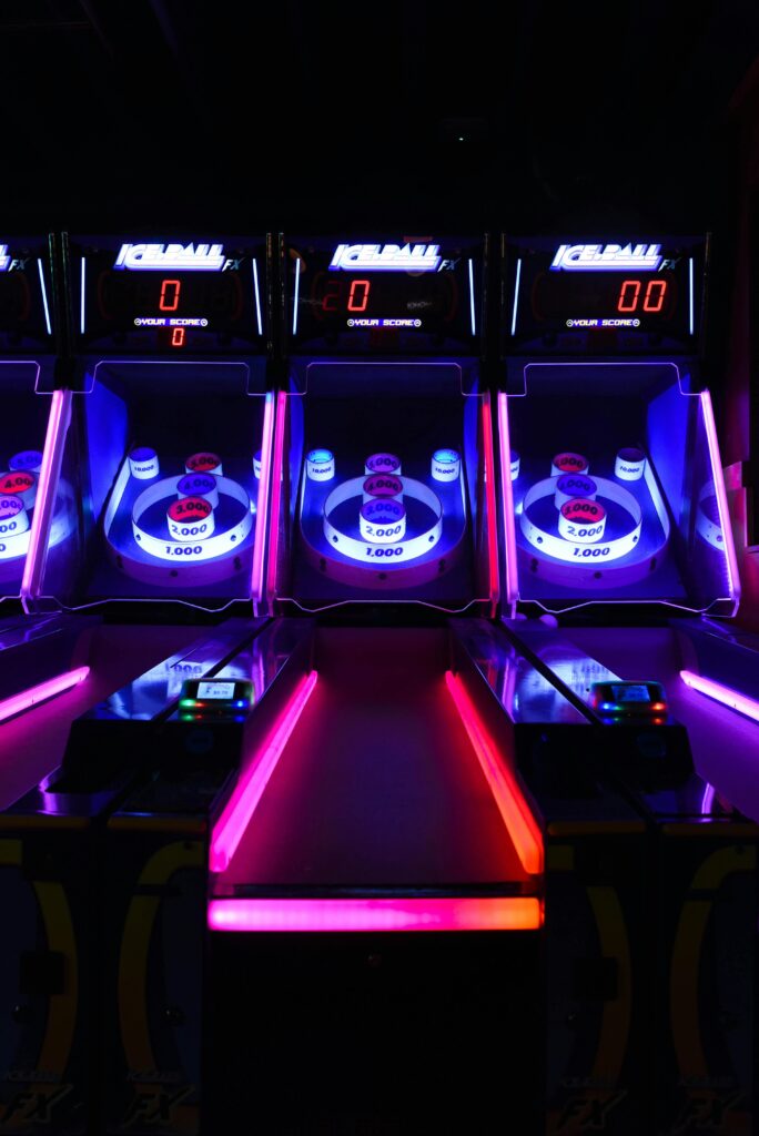 Vibrant and illuminated ski ball machines in a dark arcade setting.